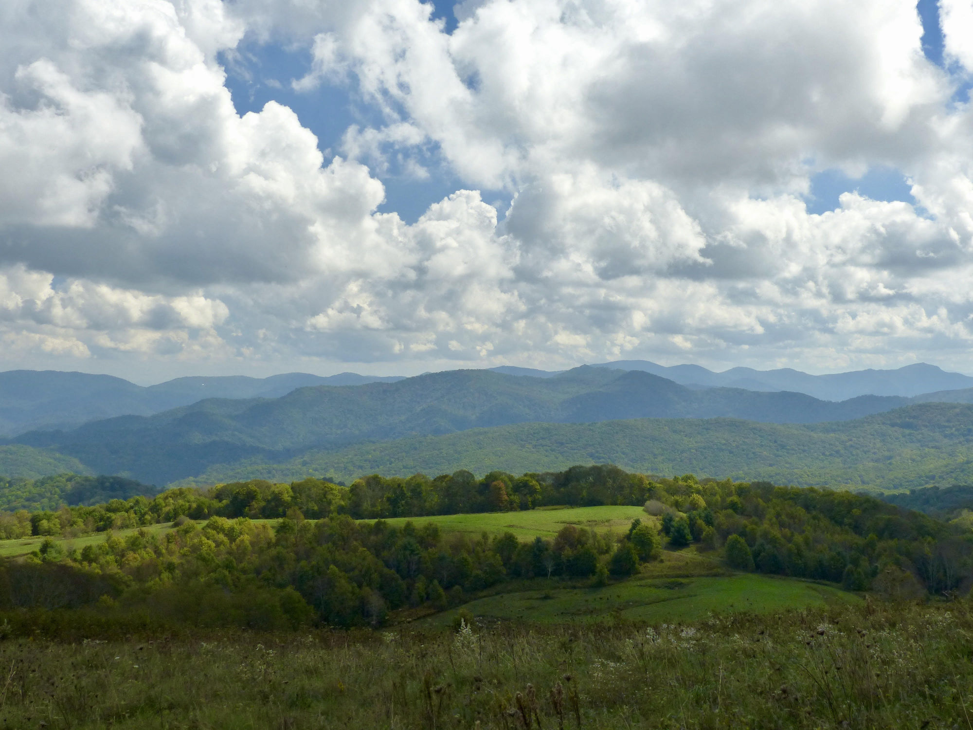 Lush green hills under a mostly overcast sky.